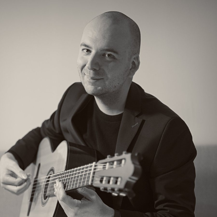 Tomás Peña smiling with his guitar, sepia photograph